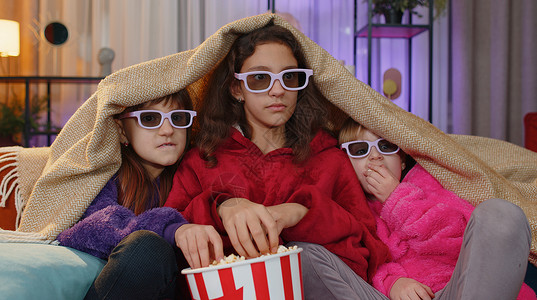 孩子们坐在沙发上吃爆米花 看有趣的电视连续剧 在家玩运动游戏电影青少年兄弟姐妹青春期惊悚片渠道活动公寓女孩娱乐背景图片