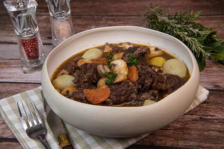 牛肉bourguignon食谱 配有美酒酱和蔬菜的炖牛肉美食草本植物食物烹饪作品土豆木头平底锅乡村桌子图片