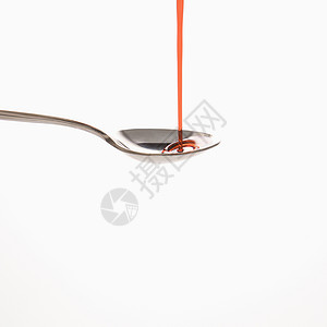 勺子和红药红色测量糖浆茶匙餐具治疗药物卫生药品保健背景