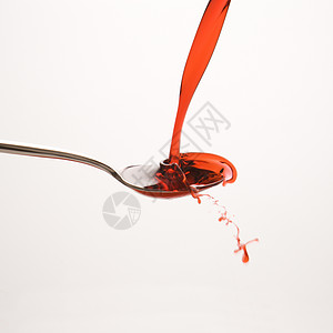 勺子和红药保健糖浆卫生测量治疗正方形药物餐具剂量红色背景
