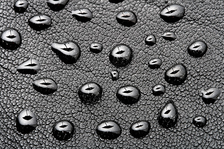 疏水黑色皮革背景上带雨伞形状的水滴背景