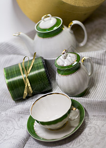 配有绿茶服务的白茶服务丝带桌子金子液体奢华盘子绿色餐具杯子古董背景图片