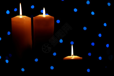 三个大蜡烛在蓝灯下点亮季节蓝色火焰假期背景图片