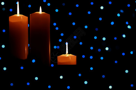 三个大蜡烛在蓝灯下点亮火焰蓝色假期季节背景图片