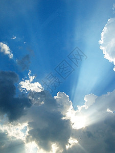 太阳在云中闪耀戏剧性射线径向白色灰色太阳光线蓝色背景图片
