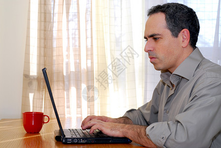 带膝上型电脑的男子商务房子记事本人士互联网投资杯子技术金融咖啡背景图片