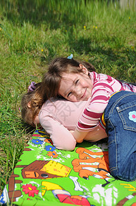 一个女孩躺在草地上黄色妹子绿色活动生态眼镜孩子们花朵晴天公园背景图片