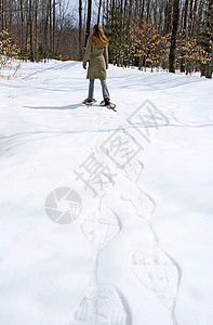 穿着雪鞋在森林中行走的妇女背景图片