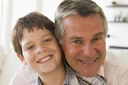 外祖父和孙子在室内微笑小男孩两个人孩子团体男生孙辈亲热婴儿潮头肩祖父背景图片