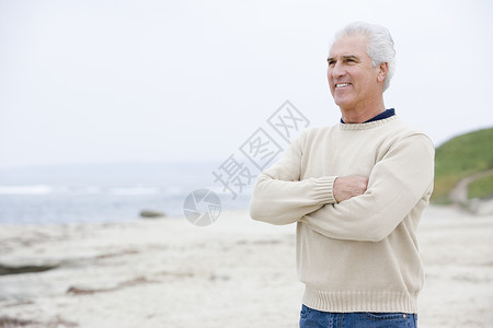 在海滩上的人手举着双臂 穿过海边微笑背景图片