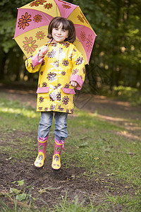 雨衣雨鞋线稿在户外的年轻女孩 带着雨伞跳跃和微笑背景