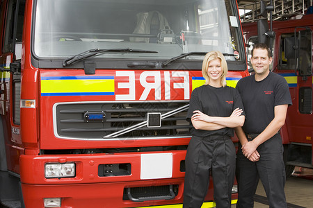 消防员站在消防机旁边的纵火者肖像女性好榜样同事中年人情况两个人伙伴水平消防消防车背景图片