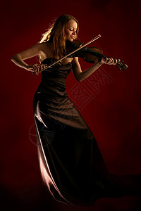 女孩玩小提琴生长女孩们女士音乐家小提琴家字符串乐器肩膀音乐幸福背景图片