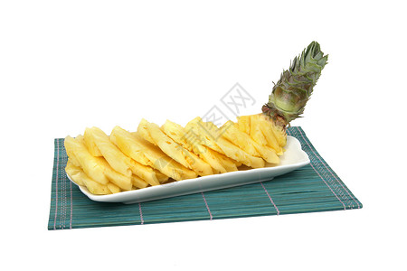 青桌垫上白瓷板上的菠萝切片背景图片