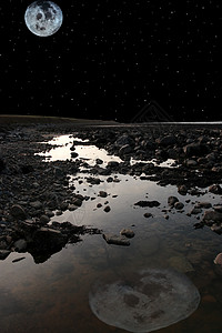 满月在岩石碧梨海滩上背景图片