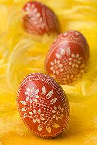 复活节鸡蛋黄色羽毛红色手工装饰背景图片