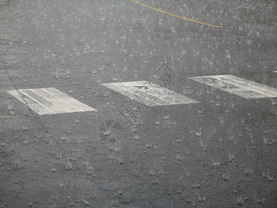 街上下大雨小路线条白色滴水风暴飞沫路面沥青穿越街道背景图片