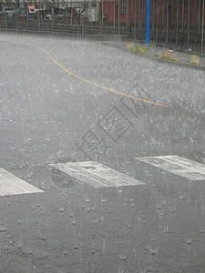 街上下大雨滴水小路街道风暴飞沫线条白色沥青穿越背景图片