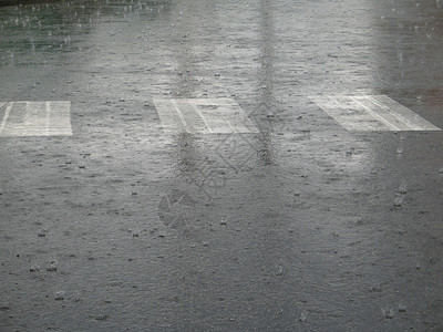 街上下大雨风暴线条穿越街道路面滴水白色小路飞沫沥青背景图片