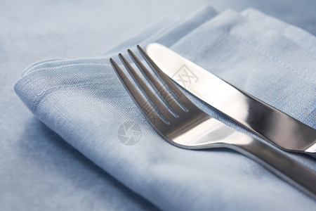 刀和叉刀叉银器水平蓝色柔焦刀具餐巾餐叉餐巾纸亚麻背景图片