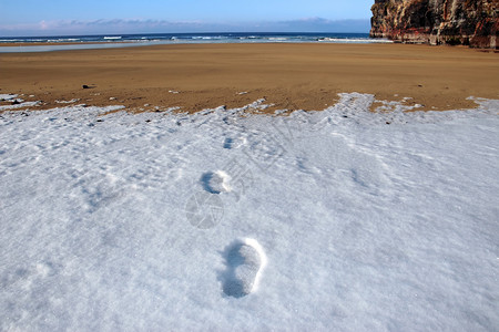 雪悬崖寒冷的冬季天空海滩上积雪脚印背景