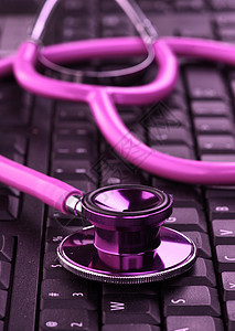 键盘上的粉色听诊器乐器笔记本技术电脑女性医疗女性化背景图片