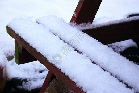 雪在椅子上桌子冷冻座位季节降雪雪花长椅木头板条背景图片