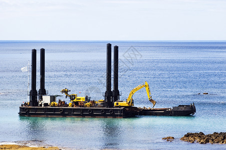 驳船码头Dredger 挖泥器大部分加载疏浚侵蚀天空管子挖掘淤泥土地蓝色背景