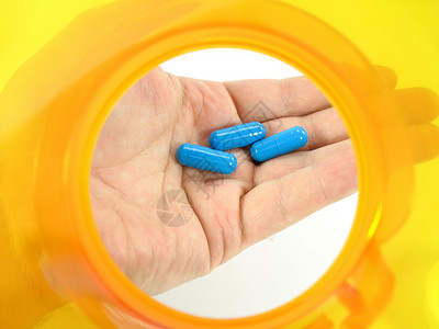 药瓶手指卫生药物保健黄色药品维生素处方胶囊蓝色背景图片