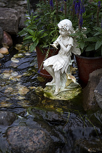 水晶体智慧石头冥想曲线岩石池塘雕塑花园绿色叶子背景图片