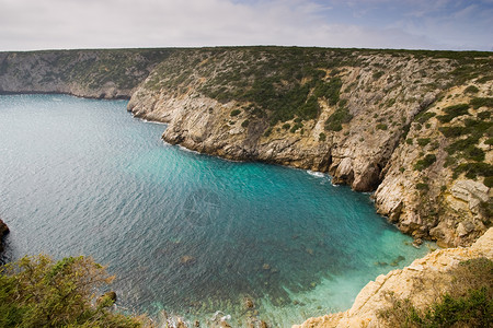 葡萄牙的小型湾蓝色海岸裂缝地形锯齿状边缘涟漪悬崖海岸线水平背景图片