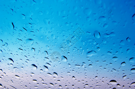 蓝色雨湿玻璃液体宏观雨滴流动圆圈反射环境气泡水分白色背景