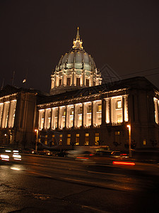 系词旧金山市政厅在夜里亮着灯光 雨后倒影街道中心雕像办公室思域草地水坑反射汽车桅杆背景