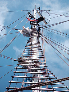 一艘旧帆船顶高高 装有操纵装置和旗帜滑轮高度用品索具海洋旅行巡航积木拉线航海背景图片