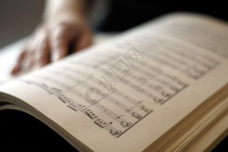 女性手在乐谱书页上歌词阅读歌曲线条分数高清图片