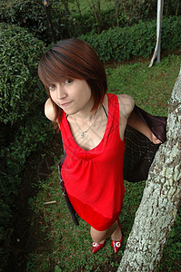 穿红袍的年轻女士公园头发配饰身体女孩黑色数字青少年青年植物背景图片