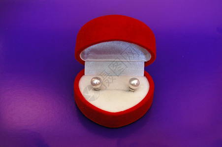 红色盒子中的珍珠耳环配件心形首饰珠子耳朵配饰紫色耳钉螺柱背景图片