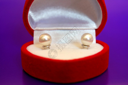 红色盒子中的珍珠耳环螺柱配饰配件心形紫色耳朵首饰珠子耳钉背景图片