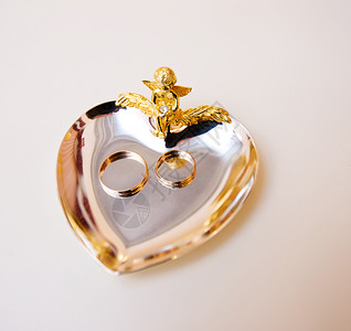 结婚戒指桌子心形珠宝宏观盘子金属订婚浪漫说谎背景图片