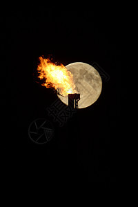 天然气火焰后面的满月石油自然资源背景图片