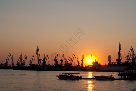 与高塔起重机相连接的海港大部分码头港口运输重量重工业商业太阳海洋日落背景图片