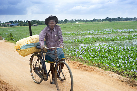 乡土气息骑自行车的男子贫困村民村庄场景胡须工人国家工作乡土冒充背景