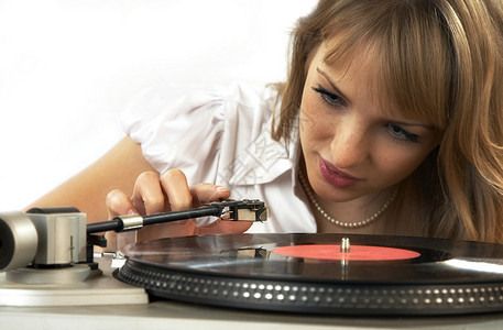 女孩听一个Vinnylic磁盘记录车削玩家兴趣姑娘音乐拼盘播放器旋转唱片背景图片