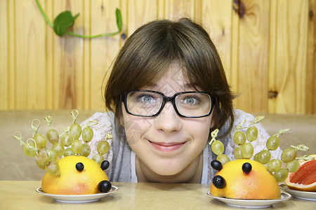 刺猬二宝快乐的女孩和可笑的刺猪 从水果在桌子上背景