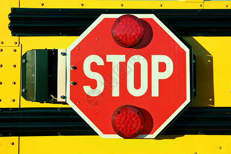 黄色校车上的红色停止签名背景图片