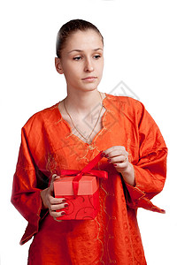 深思熟虑的穿橙色衣服 背景浅薄的女孩会送礼物高清图片