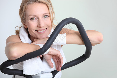 女人在锻炼机上休息片刻背景图片