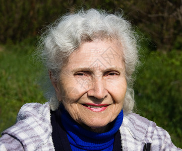 老年妇女的肖像微笑幸福成人皱纹女士祖母退休灰色背景图片