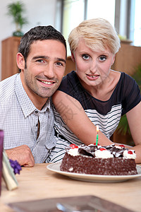 围桌有生日蛋糕的夫妇背景