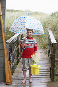 伞桶男孩带着雨伞站在人行桥上背景